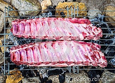 Making pork ribs on homemade improvised BBQ barbecue grill. Stock Photo