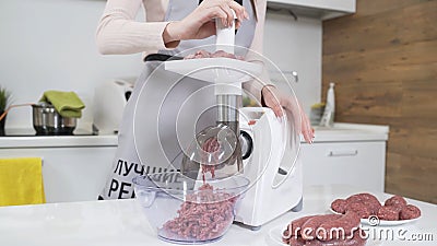 Making raw mincemeat with meat mincer at home. Pile of chopped meat. Electric mincer machine with fresh chopped meat Stock Photo