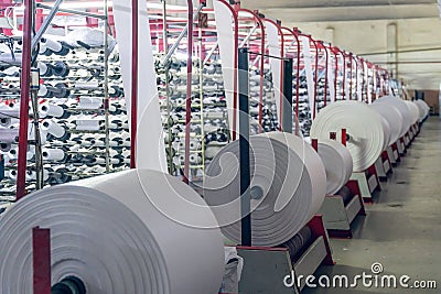 Making rolls of white polypropylene fabric on a loom Stock Photo