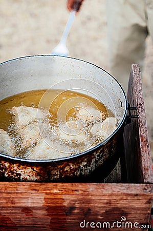 Samosa deep fried pastry snack in hot oil - Indian or African cuisine cooking Stock Photo