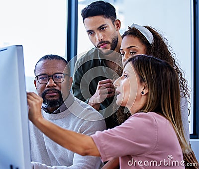 Making sense of their innovative plans. a group of businesspeople working together on a computer in an office. Stock Photo