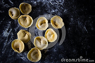 Making tortellini pasta from italian flour semolina, eggs, mushrooms top view Stock Photo