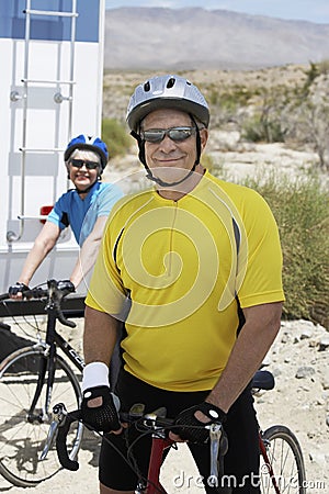 Mal Bicyclist Standing With Woman In The Background Stock Photo