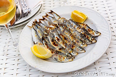 Close up of Andalusian fried sardines on white plate on white tablecloth Stock Photo