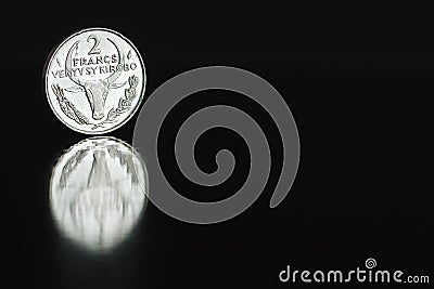 Malagasy coin two franc 1981 on the edge on black background with reflection Stock Photo