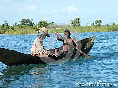 Malagasy natives crossing river by canoe Editorial Stock Photo