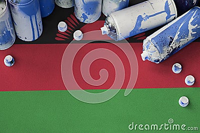 Malawi flag and few used aerosol spray cans for graffiti painting. Street art culture concept Stock Photo