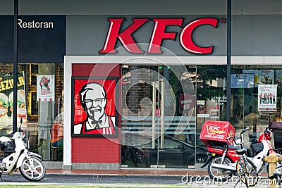 Fast food restaurant KFC view from the street, motorbike delivery service with cases refrigerators parked at entrance. Editorial Stock Photo