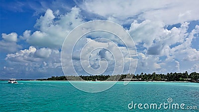 Maldives. Paradise vacation. A boat rushes across the calm aquamarine ocean. Stock Photo