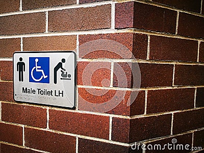 Male Accessible Toilet L-H & Baby Change, Disabled Accessible Sign on the red brick wall. Stock Photo