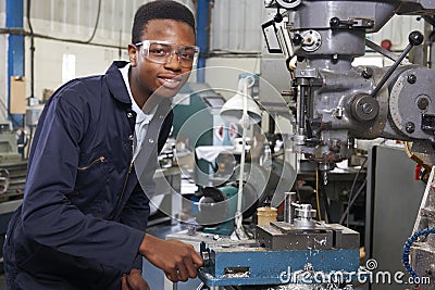 Male Apprentice Engineer Working On Drill In Factory Stock Photo