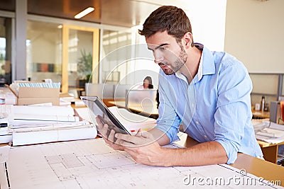 Male Architect With Digital Tablet Studying Plans In Office Stock Photo