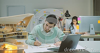 Male architect working on an architectural model in the office at night. stock video footage Male architect working on an architectural model in the office at night. stock video footage