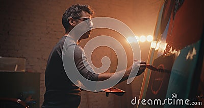 Male artisan creating abstract portrait in illuminated studio Stock Photo