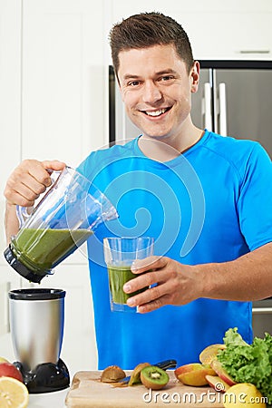 Male Athlete Making Juice Or Smoothie In Kitchen Stock Photo