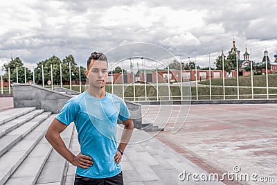 Male athlete posing and looking confidently, coach controls in summer in city. Fitness motivation youth lifestyle. Free Stock Photo