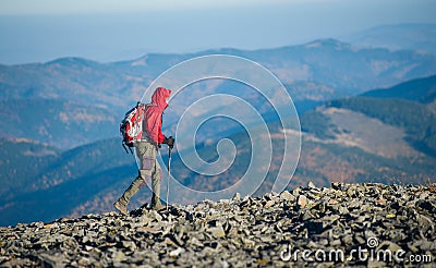Male backpaker walking on the rocky top of the mountain Stock Photo