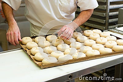 Male baker baking bread rolls Stock Photo