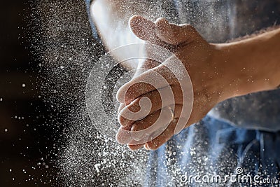 Male baker lightly flouring proofing basket for home made sourdough bread. Stock Photo
