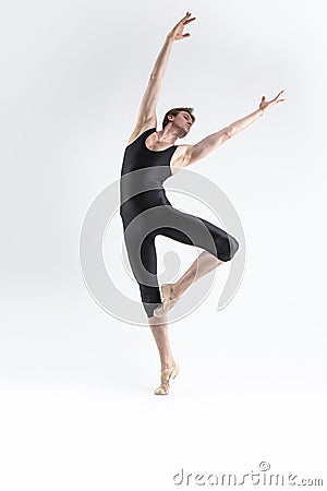 male Ballet Dancer Young Athletic Man in Black Suit Posing in Ballanced Stretching Dance Pose Studio On White Stock Photo