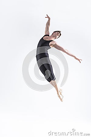 Male Ballet Dancer Young Man in Black Dance Suit Posing in Flying Ballanced Dance Pose Studio Stock Photo