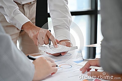 A male banker calculates a business`s financial turnover, using a calculator Stock Photo