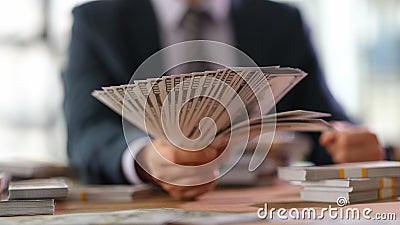Male banker holding fan of dollar banknotes closeup Stock Photo