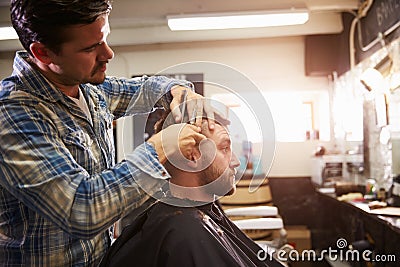 Male Barber Giving Client Haircut In Shop Stock Photo