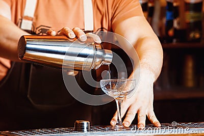 Male bartender is making cocktail pouring alchohol Stock Photo