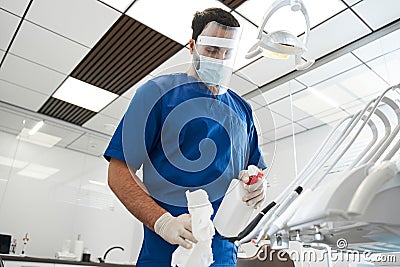 Male bearded dentist carefully sterilize the medical equipment Stock Photo