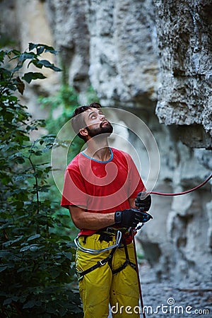 Male belayer with the rope under the cliff Stock Photo