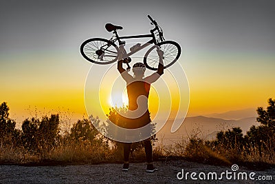 Male biker holds bike above head Stock Photo