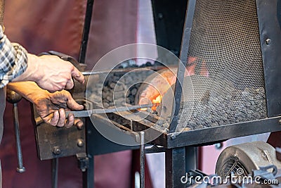 Male blacksmith working in workshop, London. Concept Editorial Stock Photo