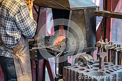 Male blacksmith working in workshop, London. Concept Editorial Stock Photo