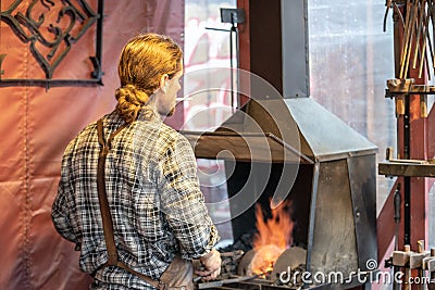 Male blacksmith working in workshop, London. Concept Editorial Stock Photo