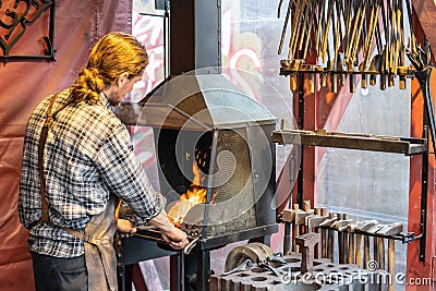 Male blacksmith working in workshop, London. Concept Editorial Stock Photo