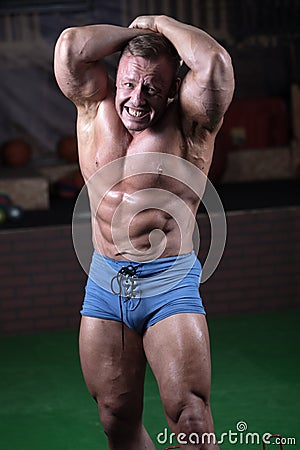 Male bodybuilder posing in the gym. Male athlete shows off his figure Stock Photo