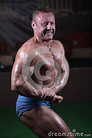 Male bodybuilder posing in the gym. Male athlete shows off his figure Stock Photo