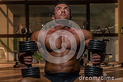 Male bodybuilder resting after doing heavy weight exercise Stock Photo