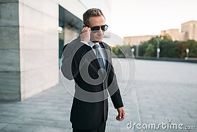 Male bodyguard talking by security earpiece Stock Photo
