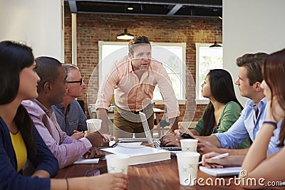 Male Boss Addressing Office Workers At Meeting Stock Photo
