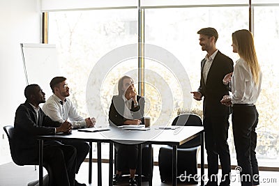 Male boss introduce female newcomer at meeting Stock Photo
