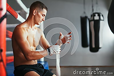 Male boxer is wrapping hands with boxing wraps Stock Photo