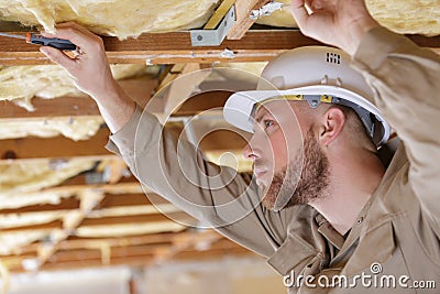 male builder working on ceiling joists Stock Photo