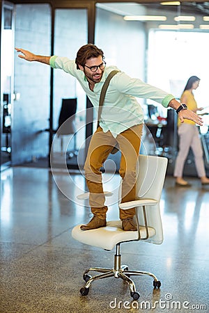 Male business executive standing on chair Stock Photo