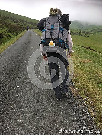 Male Camino pilgrim walking up the steep Pyrenees from St Jean. Stock Photo