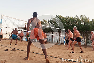 male Caucasians, Arabs, Africans playing volleyball on the beach Editorial Stock Photo