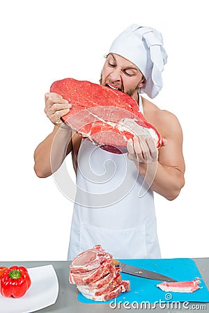 Male chef bodybuilder eats raw meat. Stock Photo