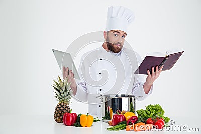 Male chef cook holding tablet computer and receipe boo Stock Photo