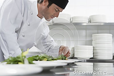 Male Chef Preparing Salad In Kitchen Stock Photo